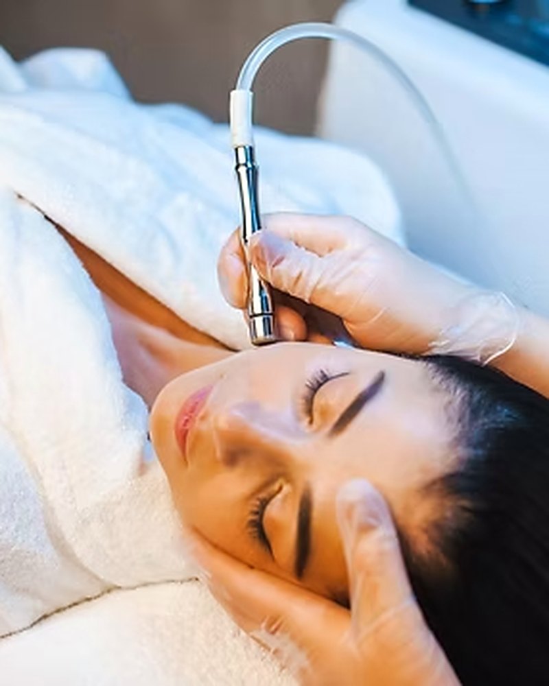 Esthetician giving a microdermabrasion treatment