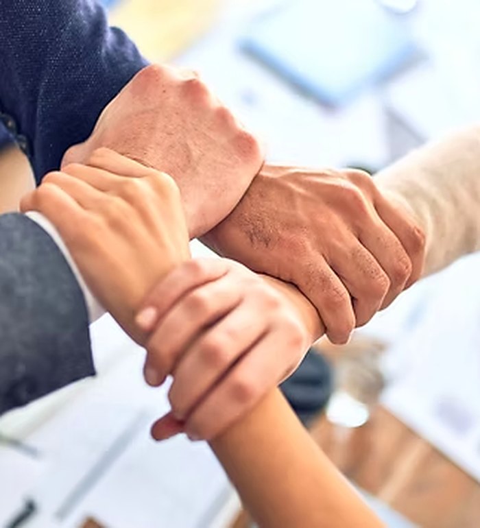 Team members joining hands